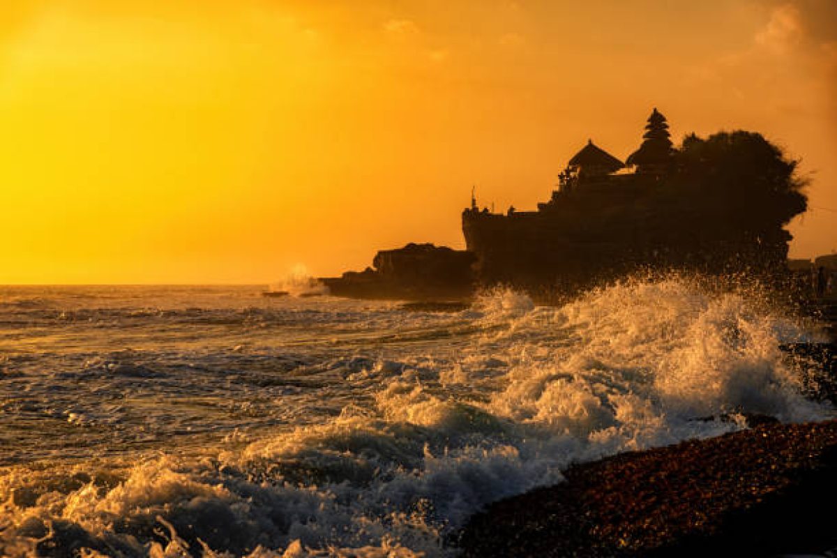 Silhouette of Tanah Lot temple in golden sunset it the most attraction and travel destination of Bali, Indonesia. Tanah Lot is Hindu temple